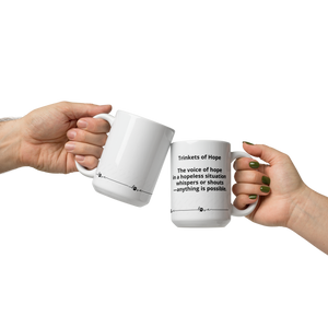Two hands holding white mugs with text  that says, "Trinkets of Hope. The voice of hope in a hopeless situation whispers or shouts - anything is possible." with a line and a dogs paw around the bottom.on a white background
