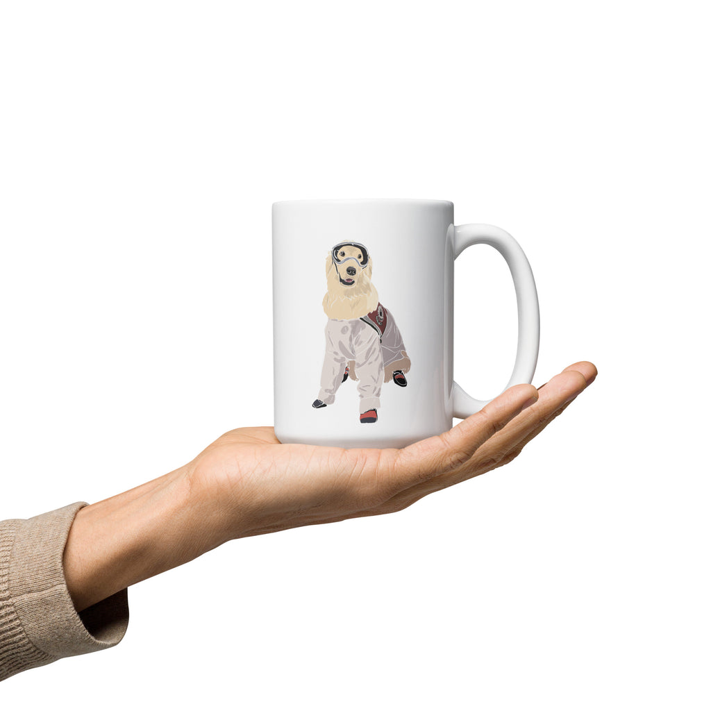 A white mug being held in a persons hand. The illustration on the front is of Sampson wearing lab gear.